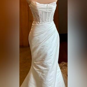 Size 16, fits like 12. Willow and winter wedding gown. NEVER WORN OR ALTERED.